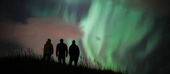 Travellers admiring the phenomenon of the Aurora Borealis in Iceland